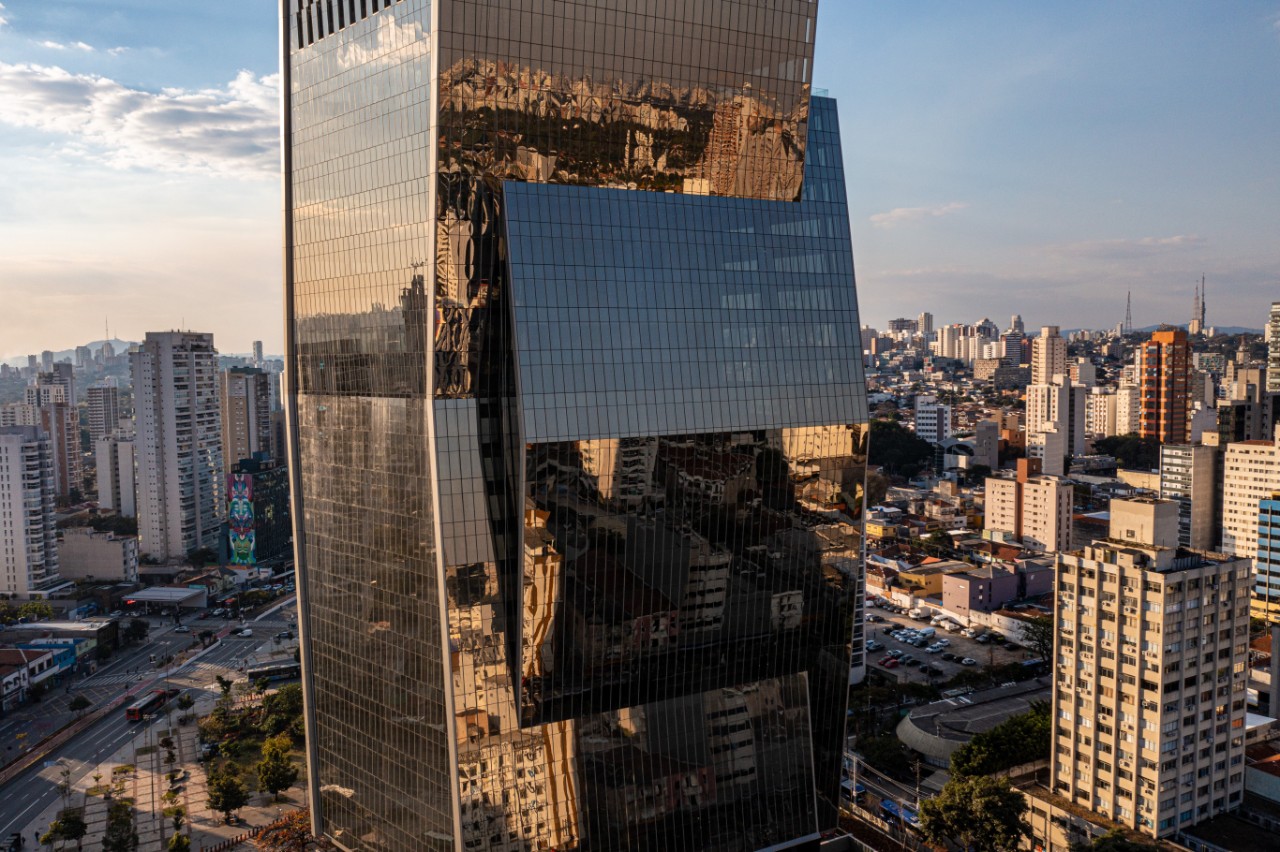 Faria Lima Plaza (“FLP”) is a AAA office tower located on Avenida Faria Lima. The concept of the design is that of an ‘embrace’ of two forms elegantly and dynamically interlocked in a dance.

The tower floor plates vary slightly in size allowing for a variety of tenant options.

The material palette of bronze and glass with a dramatic, dark core is unique. The composition sits atop a contrasting, white granite stepped platform amidst a landscaped plaza replete with serene water features and benches tucked under the lifted tower.

Product used: Neutral Plus 50 laminated with pvb bronze